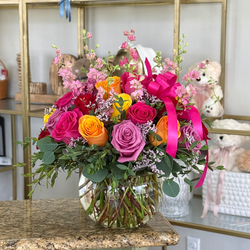 Fuchsia Ember hot pink and orange rose arrangement with fuchsia, lavender, red, yellow and orange roses in a clear glass vase
