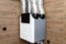 Home mechanical ventilation with heat recovery hanging on the wall in a modern gas boiler