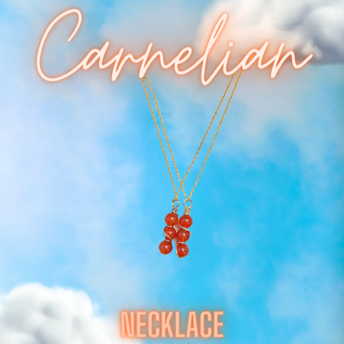Blue sky background with clouds in the right and bottom left corners. In the center of the image is two gold wire wrapped carnelian gemstone necklaces . each necklace has three gemstones.