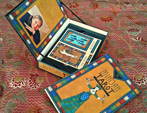 The Minoan Tarot deck in its box with the lid open and the companion book propped alongside it