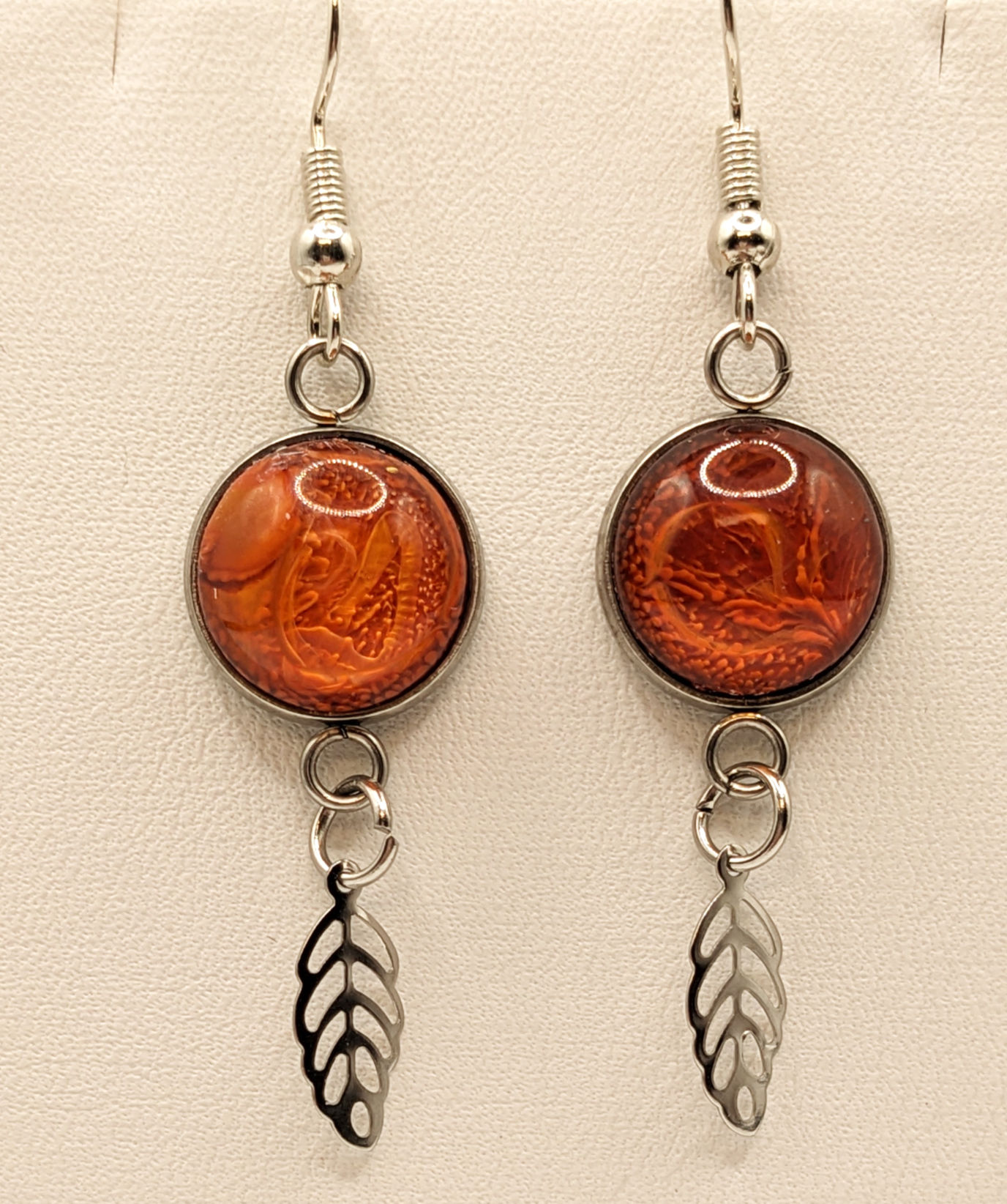 lovely burnt orange petri effect resin earrings with feather charm