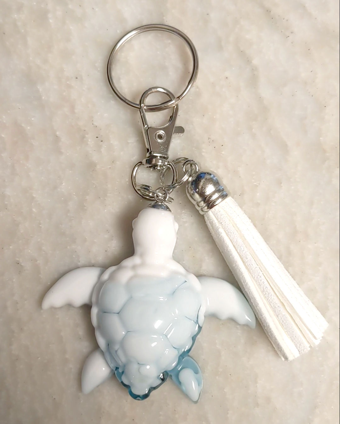 white and blue turtle keychain with tassel