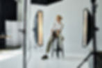 Fotógrafo sentado en taburete en estudio con luces