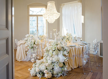 Festlich gedeckte runde Tische mit weißen Blumen im Salon der Villa Waldeck