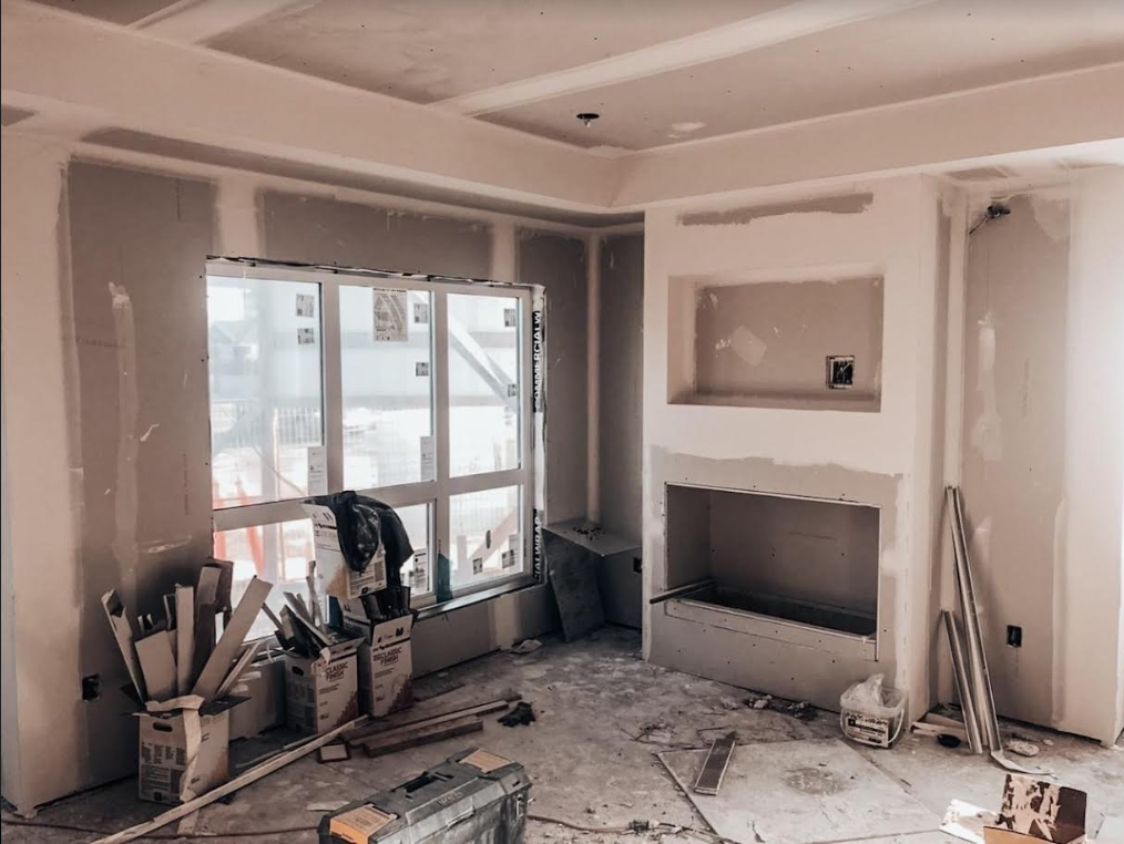 Residential drywall boarded and taped around a fireplace; visible joints and unfinished ceiling.