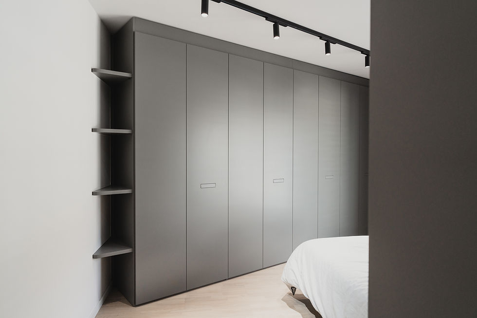 Armoire dressing sur mesure dans une chambre parentale avec mur en biais. Niches ouvertes dans les angles de la pièce.