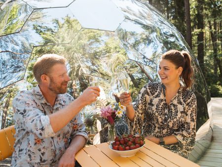 par som skrattar vid glamping dome i skogen