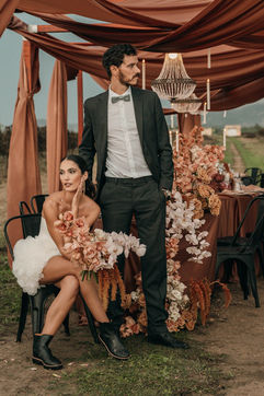 Brautpaar an Hochzeitstafel zwischen Weinreben bei Destination Wedding