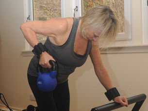 A refomer pilates class with a kettlebell