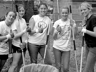 Black and white photo of 5 female volunteers with tools