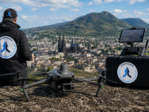 Télépilote AUVER'Drones préparant une mission d'inspection par drone professionnel à Clermont-Ferrand avec vue sur le puy de Dôme et l'agglomération auvergnate.
