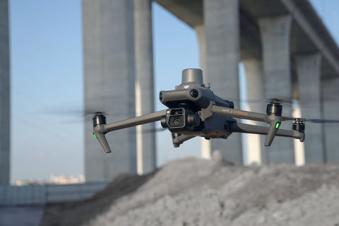 Drone Mavic 3 Enterprise en vol devant un pont imposant en arrière-plan. Le drone, conçu pour des applications professionnelles, est équipé de capteurs et d’une caméra haute résolution, idéal pour des missions de surveillance et d’inspection. 