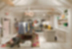 The interior of the Tommy Hilfiger Prep World pop-up retail activation, with white plank board walls, vaulted ceiling, and beams, a custom chandelier made of tennis rackets, as well as a point of sale, and merchandise display.
