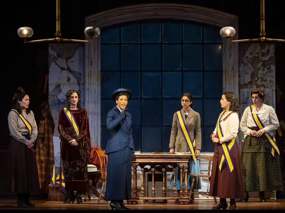 Nikki M. James and the Broadway cast of Suffs perform the song "Wait My Turn" on a set of a large arched window and wall with a scenically distressed paint finish.