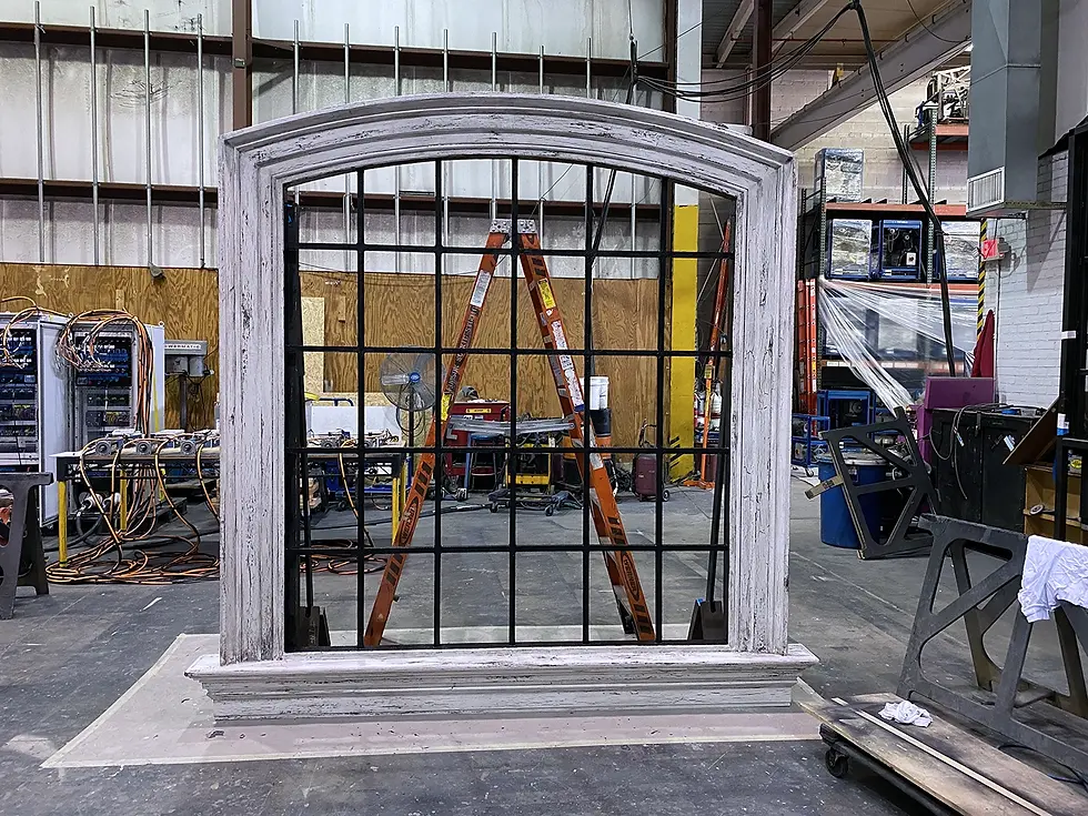 A scenic arched window with mullions and scenically distressed frame, assembled at Hudson Scenic Studios's fabrication shop for the Broadway production of Suffs.