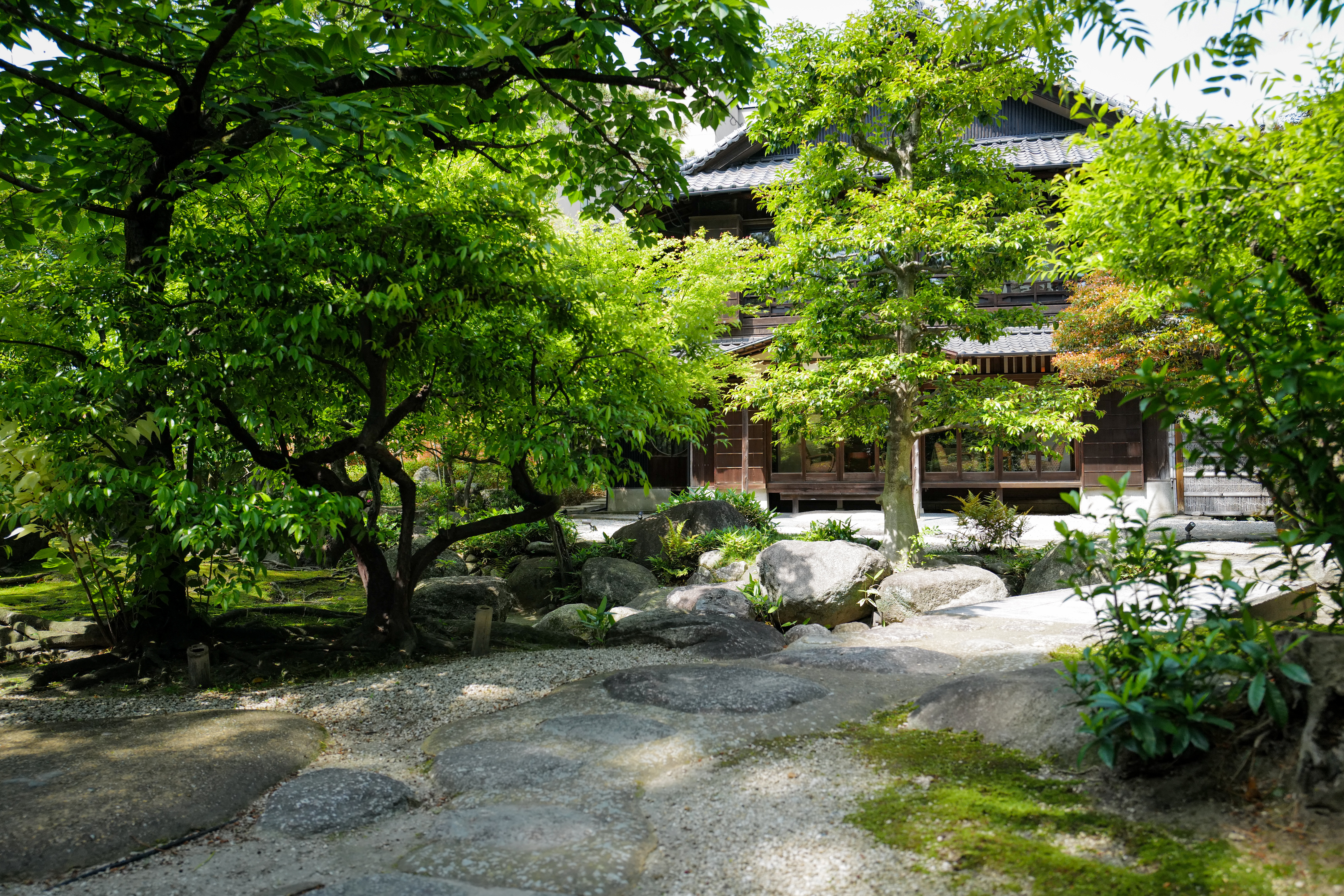 尾上別荘の建物と白砂利・石組みのある庭。整備された日本庭園の様子