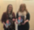 Katy Bradford (left) and Marisa Cargill (right) pose in front of the doors to their conference session room. Both are holding a copy of the printed conference program.