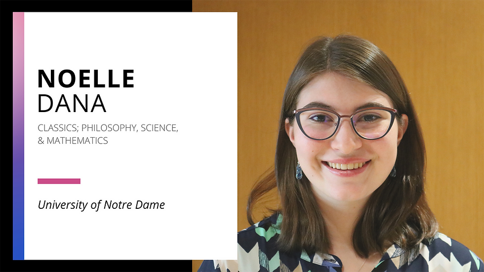 Photo of Noelle, standing inside a campus building, smiling directly at the camera wearing a geometric pattern shirt