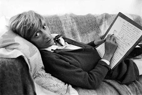 Françoise Sagan allongée sur un canapé un manuscrit à la main