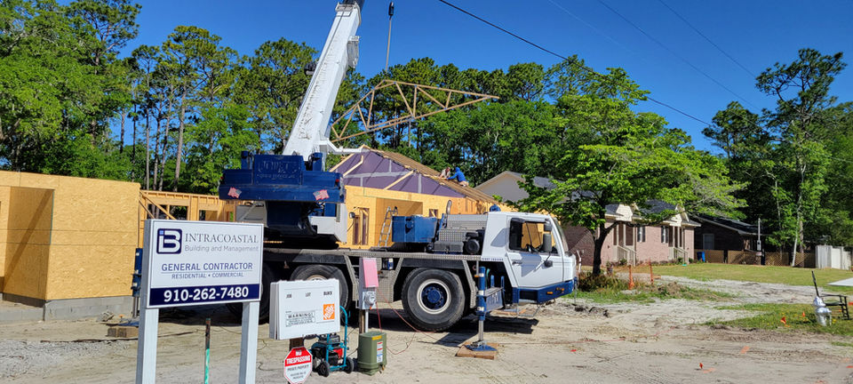 Crane lifting roof trusses at an Intracoastal site.