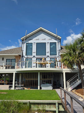 Modern house under renovation with large windows and balcony
