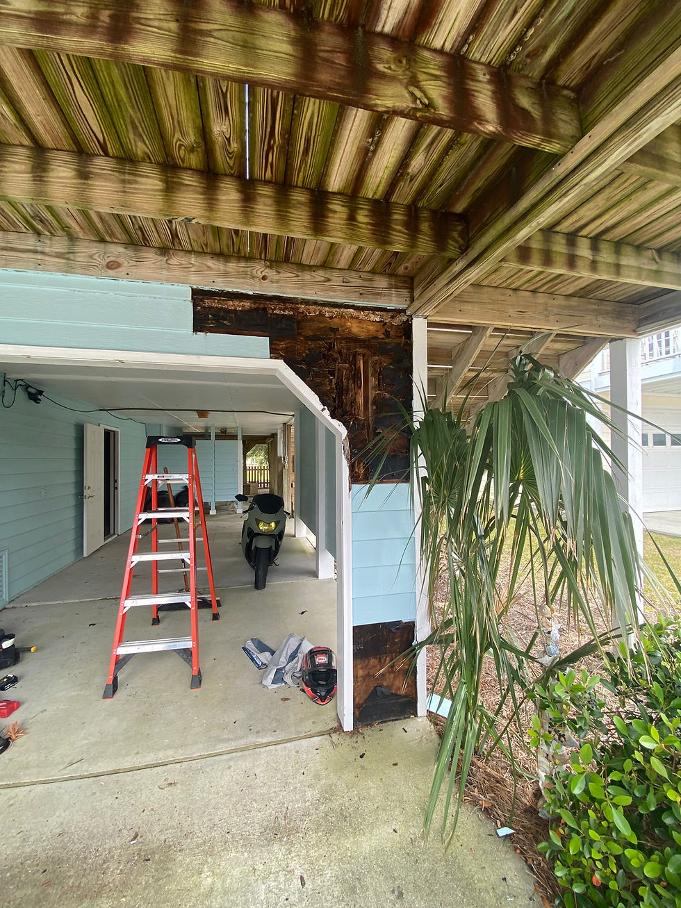 Wood rot repair on house siding under a deck.