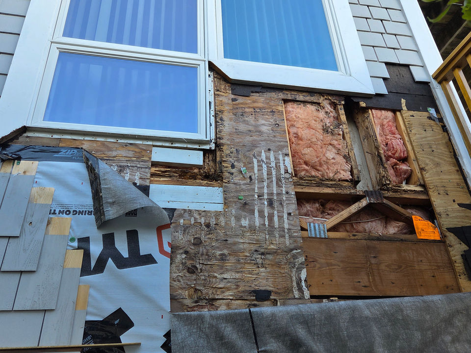 Exposed wall insulation and water damage under window exterior
