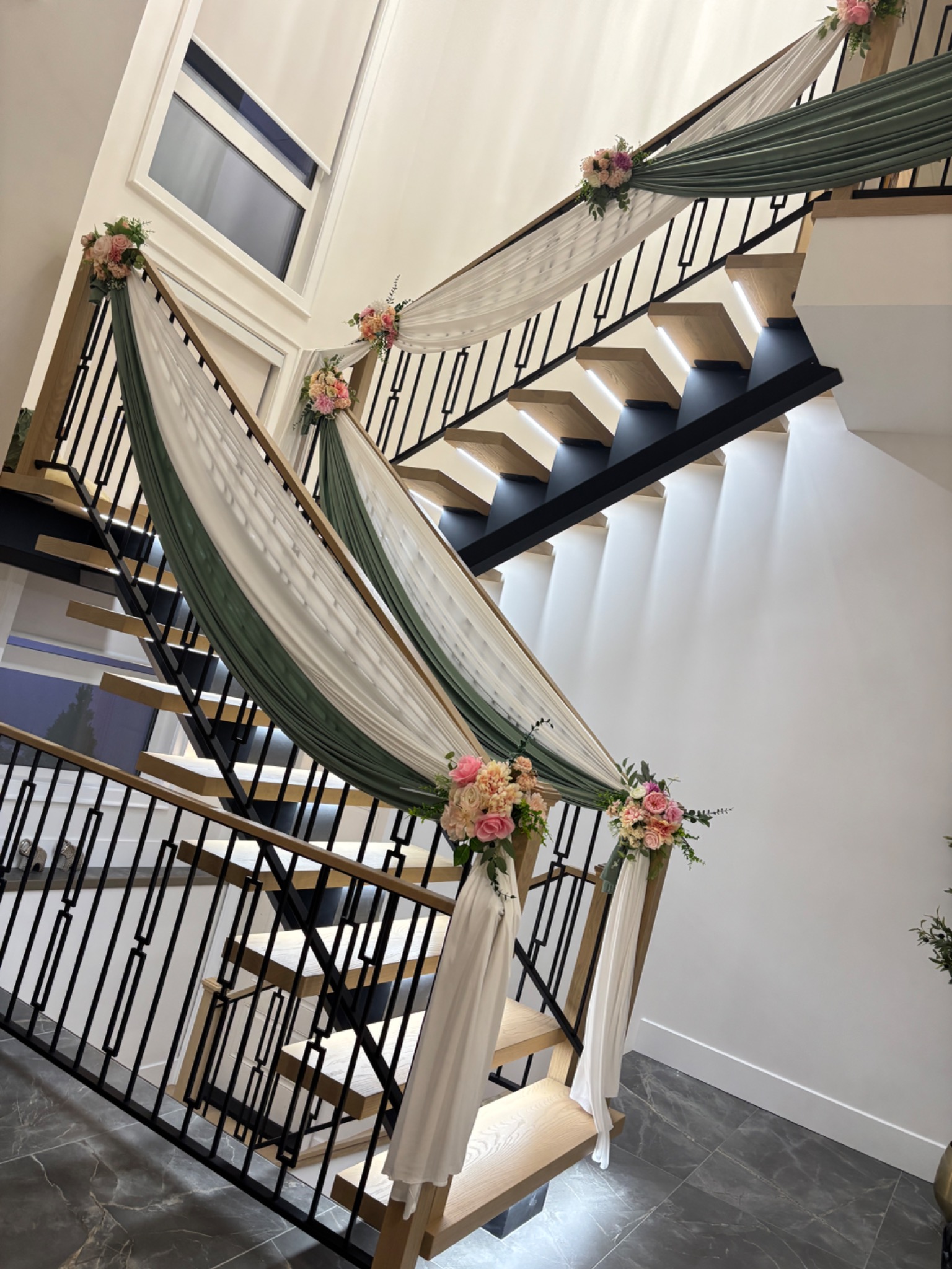 Sage and ivory stair draping with floral accents styled by Muse Events