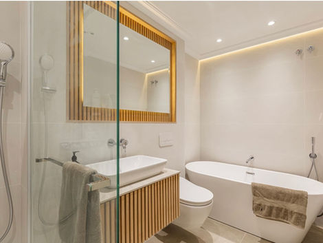 Bespoke modern bathroom with wooden decorative elements and LED backlighting - Alchemy Interiors