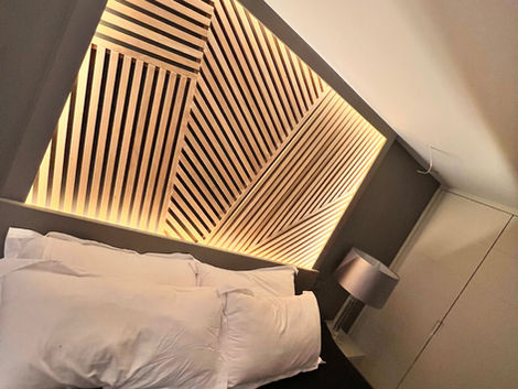 Bespoke wooden headboard wall with LED backlighting and geometric design - Alchemy Interiors