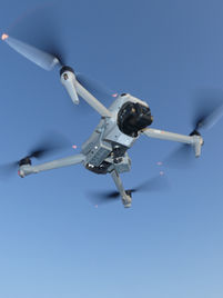 Drone with inspection sensors near a bridge. Enables safe, precise aerial inspections for tall structures or pipelines.