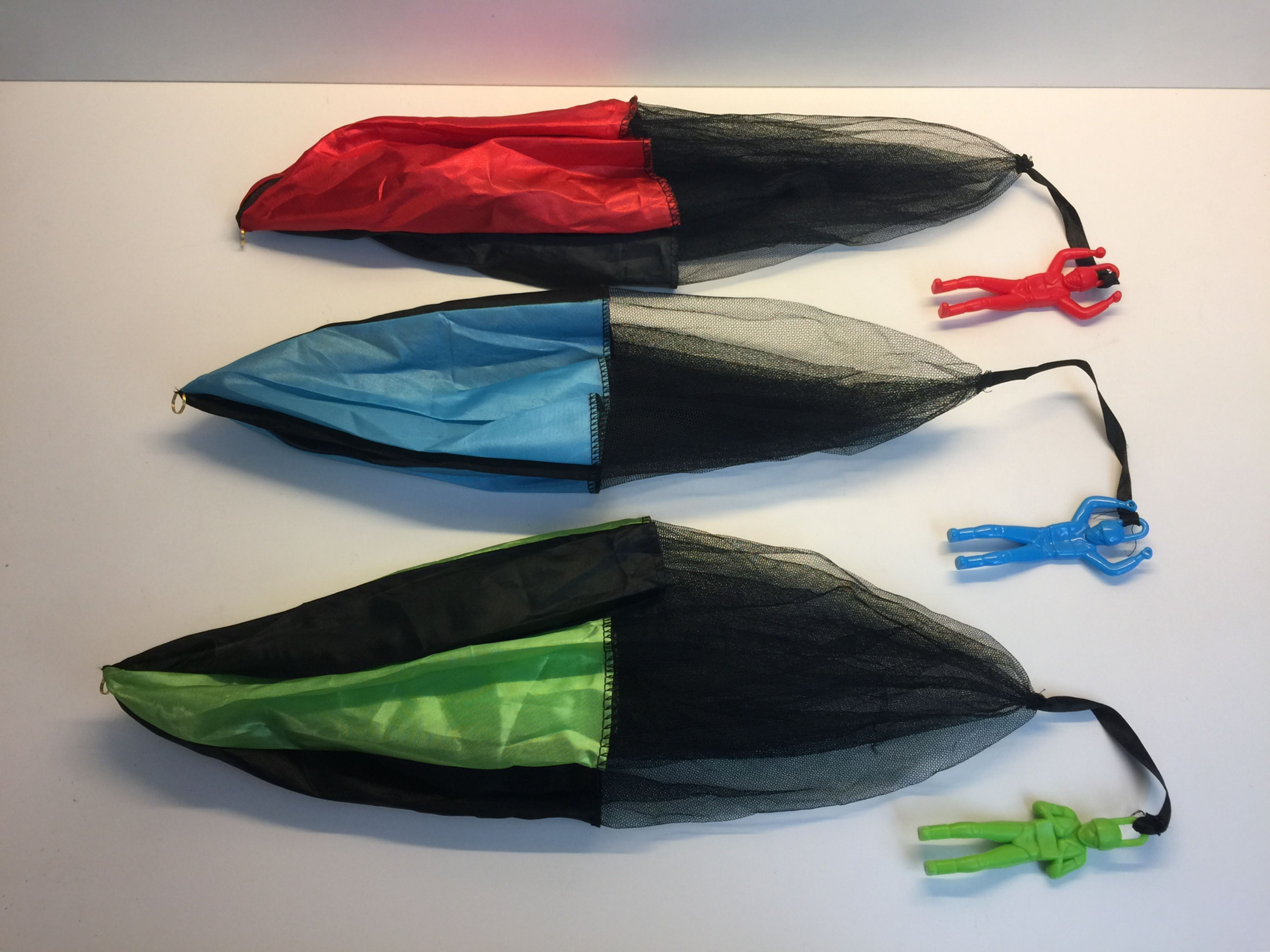 Three colorful parachutes being dropped from a drone, that can carry small payloads to ease the decent.