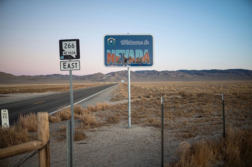Welcome to Nevada sign and Route 266 East on a desert road