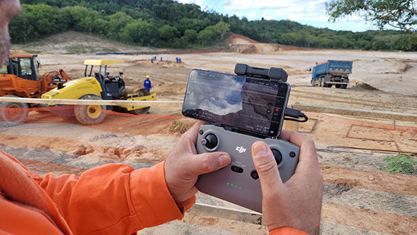 MÃO DE PILOTO DA DRONE DA BAHIA SOBRE UM RC DJI CONTROLANDO DRONE EM OBRA