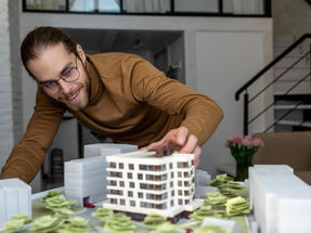 Arquiteto observando a construção da maquete do empreendimento