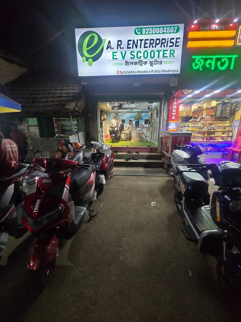 A.R. ENTERPRISE electric scooter showroom entrance with glowing brand signboard in Sutahata, Haldia.