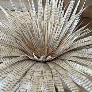 Lila, l’une des filles du vent et des mots.

Dans mon atelier, où les papiers de livres tourbillonnent comme des pensées en mouvement, Lila est née. Elle appartient à la collection "Girls", une longue série de fleurs qui racontent chacune une histoire unique, faite de délicatesse et de caractère.

Lila se tient fièrement droite sur son socle en béton et bois flotté. Ses pétales sont ouvert vers le soleil, découpés dans  d’anciens livres aux pages jauni par le temps.
Elle est un hommage à la poésie du quotidien, à ces moments où les matières ordinaires se transforment en trésors. Lila incarne l’esprit de la collection "Girls" : un mélange d’élégance, de créativité et de la magie qui naît dans un atelier où chaque création est une renaissance.