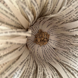 une fleur artisanale unique réalisée à partir de papier de livres recyclés, montée sur un socle en béton et agrémentée de bois flotté. Parfaite pour apporter une touche naturelle et artistique à votre intérieur.