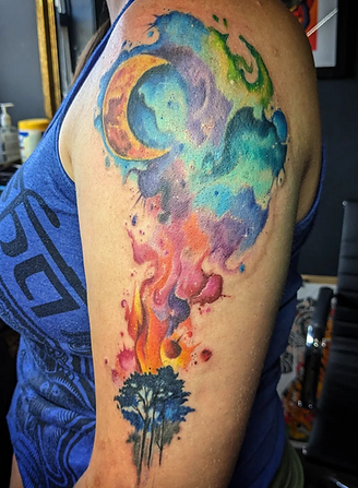 Watercolor moon and fire tattoo on a woman's shoulder