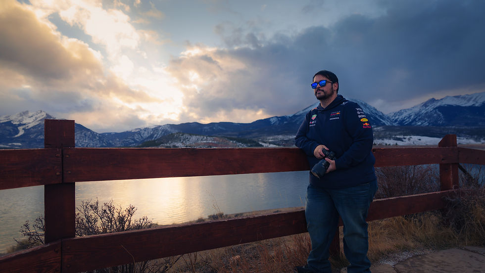 Denver portrait photographer Matt Archuleta standing outdoors with camera.