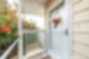 glass storm door over the white door with hanging flower decoration