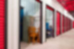 Corridor of self storage unit with red doors.