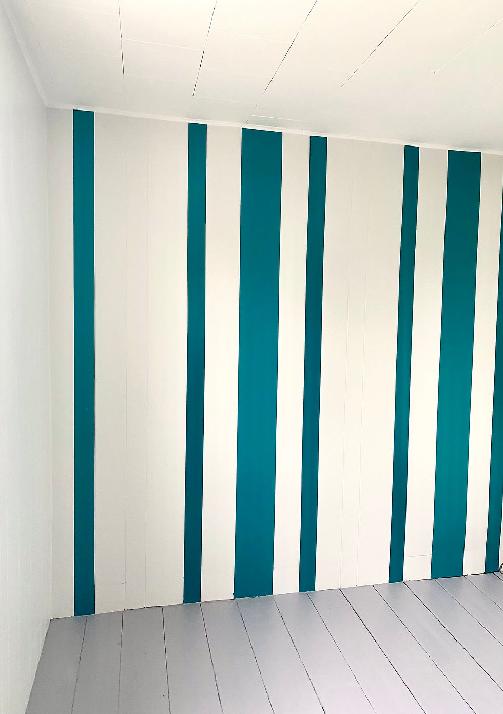 une pièce aux murs rayés bleus et blancs