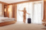 a person walking with a suitcase in a hotel room