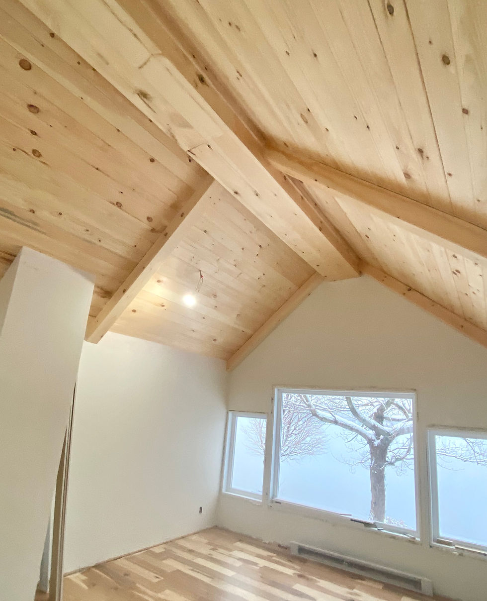 une pièce avec plafond et fenêtres en bois