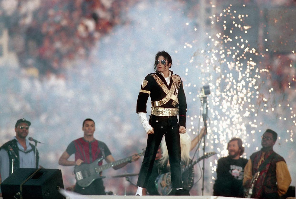 Michael Jackson stands center stage during the Super Bowl XXVII halftime show as fireworks erupt behind him.