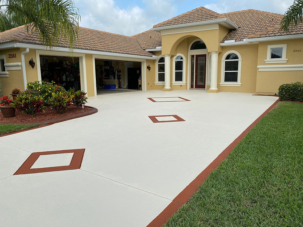 Yellow house with beige driveway featuring brown square patterns