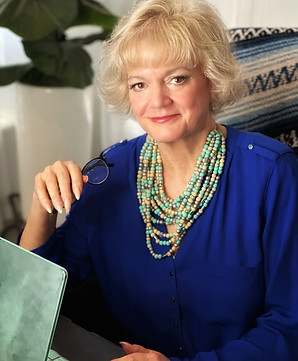 a photo of Sheri Skousen at a laptop, short brownish blonde hair, blue shirt