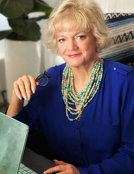 a photo of Sheri Skousen at a laptop, short brownish blonde hair, blue shirt