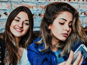 dos mujerestomandose una selfie con un iphone